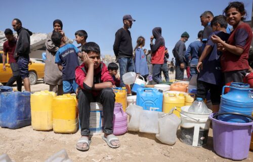 Palestinians attempt to collect water at a camp for displaced people in Gaza City